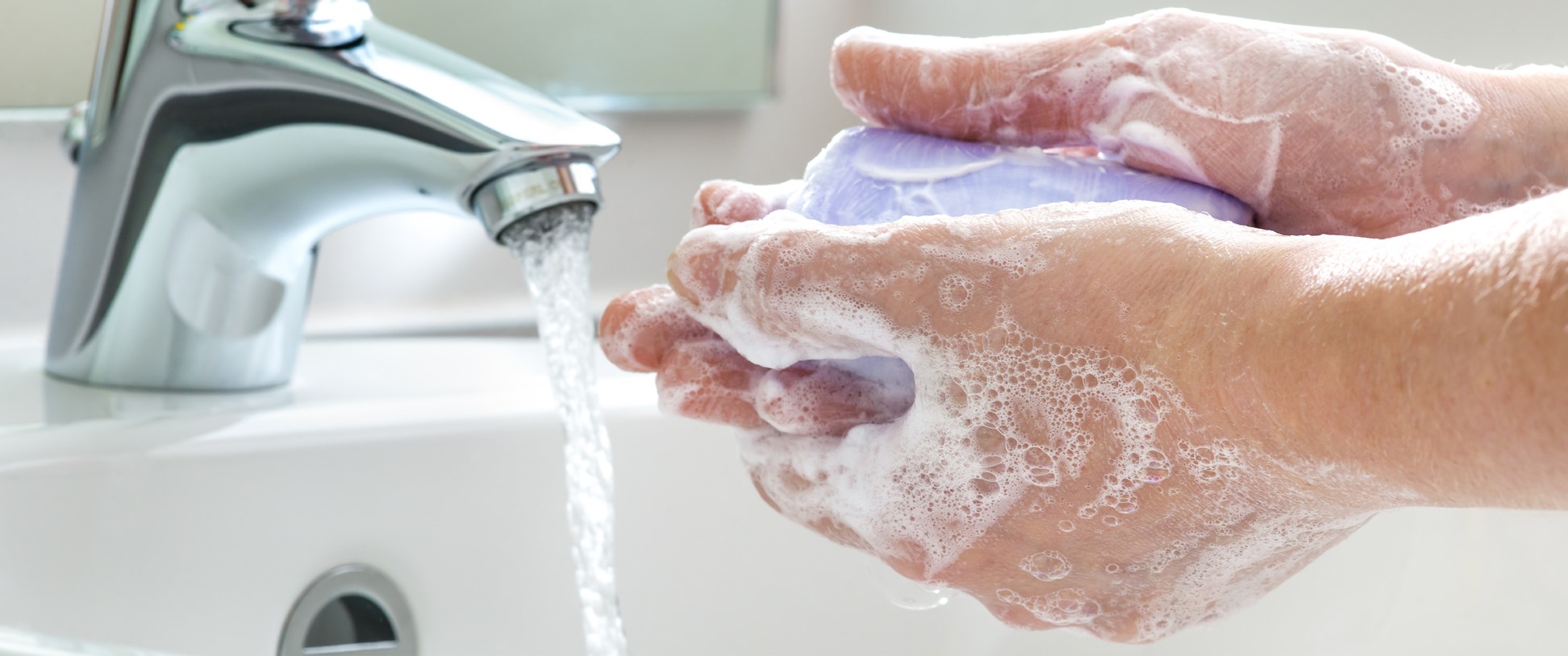 soapy hands under faucet with running water